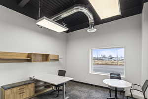 Office featuring baseboards and dark colored carpet