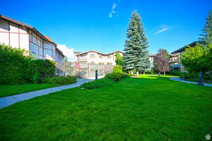 View of home's community with a yard, fence, and a residential view