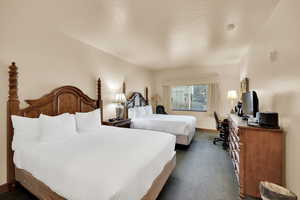 Bedroom featuring baseboards and dark colored carpet