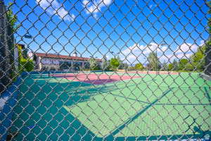 View of tennis court featuring fence