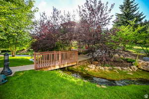 View of property's community featuring a wooden deck and a lawn