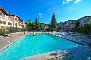 Pool with a patio area, a residential view, and fence
