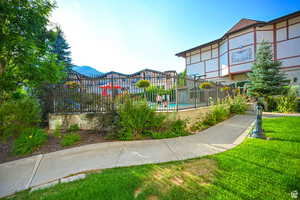 View of property's community with a pool, a yard, and fence