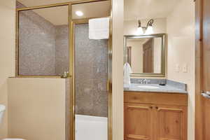Full bath with toilet, a stall shower, and vanity