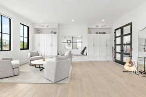 Living area with light wood-style flooring, french doors, and recessed lighting