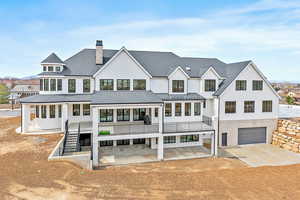 Back of home with covered deck and patio