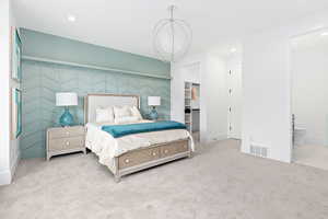 Carpeted bedroom featuring baseboards, visible vents, recessed lighting, and an accent wall