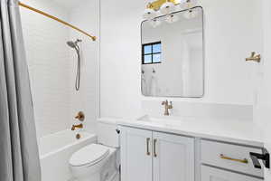 Full bathroom with toilet, shower / bath combination with curtain, and vanity