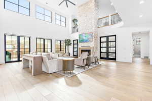 Living area featuring a stone fireplace, visible vents, a healthy amount of sunlight, and light wood finished floors