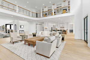 Living room with baseboards, a high ceiling, recessed lighting, and hardwood floors