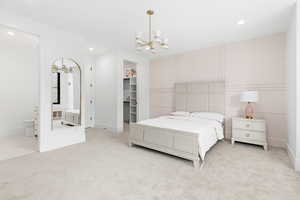 Bedroom featuring light colored carpet, recessed lighting, a spacious closet, and an inviting chandelier
