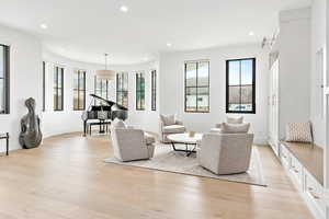 Living room featuring baseboards, hardwood flooring, and recessed lighting
