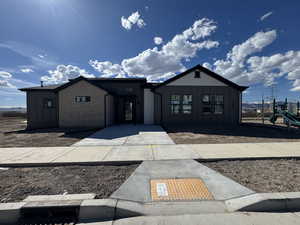 View of Clubhouyse Pool behind  featuring board and batten siding and a playground