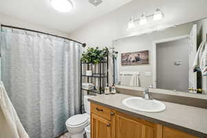 Bathroom with visible vents, toilet, and vanity