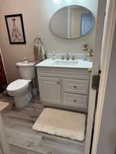 Bathroom with wood finished floors, toilet, and vanity