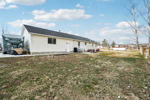 Back of house featuring a yard, a patio area, fence, and entry steps