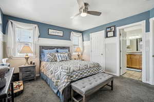 Bedroom with connected bathroom, multiple windows, ceiling fan, and light colored carpet