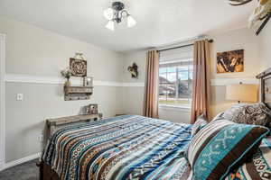 Carpeted bedroom with baseboards and a textured ceiling