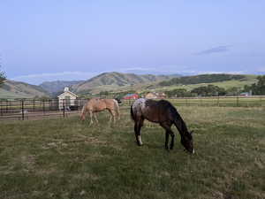 View of stable featuring a mountain view and a rural view