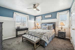 Carpeted bedroom featuring baseboards, ceiling fan, and a textured ceiling