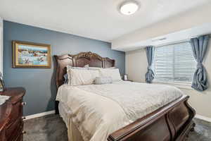 Bedroom with baseboards, visible vents, and carpet