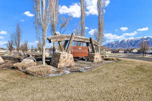 Community sign featuring a residential view, a mountain view, and a yard