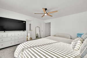 Bedroom featuring connected bathroom, ceiling fan, and a textured ceiling