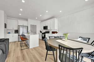 Dining area with light wood-style floors, recessed lighting, and a textured ceiling