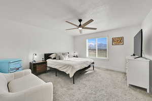 Bedroom featuring baseboards, ceiling fan, carpet, and a textured ceiling