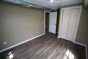 Unfurnished bedroom featuring baseboards, visible vents, a closet, and dark wood finished floors