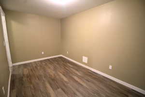 Empty room with baseboards and dark wood finished floors