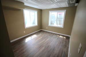 Unfurnished room with an ornate ceiling, wood finished floors, and baseboards