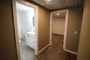 Hall featuring baseboards, visible vents, dark wood-style flooring, and recessed lighting