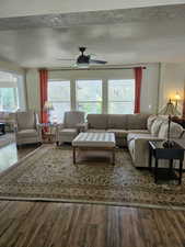 Living room with a textured ceiling, a wealth of natural light, and wood finished floors