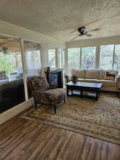 Sunroom / solarium with an outdoor living space, wood finished floors, a healthy amount of sunlight, and a ceiling fan