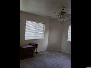 Carpeted empty room with baseboards and ceiling fan