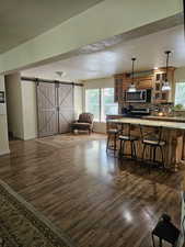 Kitchen featuring glass insert cabinets, decorative backsplash, appliances with stainless steel finishes, and dark wood-style flooring