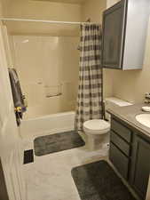 Full bathroom with toilet, vanity, and shower / bath combo