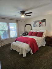Carpeted bedroom with a ceiling fan
