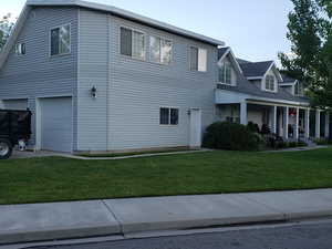 View of side of home featuring a yard and an attached garage