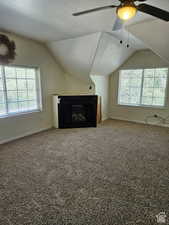 Additional living space featuring ceiling fan, baseboards, carpet flooring, and lofted ceiling