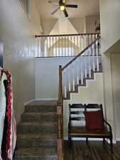 Stairs featuring baseboards, wood finished floors, and a ceiling fan