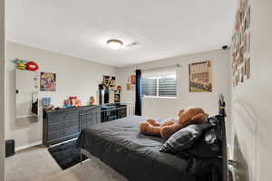 Carpeted bedroom featuring baseboards and visible vents