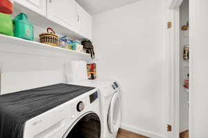 Washroom with baseboards, separate washer and dryer, and cabinet space