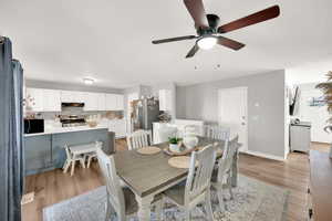 Dining space featuring baseboards, ceiling fan, and light wood-style flooring