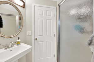 Bathroom featuring an enclosed shower and a sink