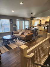 Living room featuring a ceiling fan, lofted ceiling, recessed lighting, dark wood-type flooring, and a textured ceiling