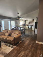 Living room with visible vents, dark wood-type flooring, a textured ceiling, lofted ceiling, and ceiling fan