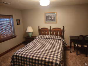 Carpeted bedroom featuring baseboards, visible vents, and a textured ceiling