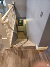 Staircase featuring baseboards and wood finished floors